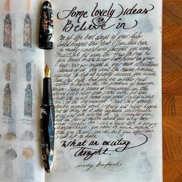 Handwritten letter on paper with a fountain pen on a wooden surface